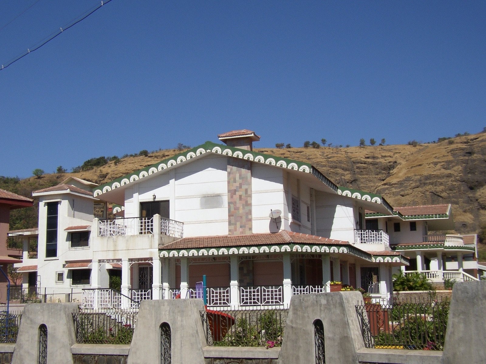 Compound wall with arched niches, hills behind